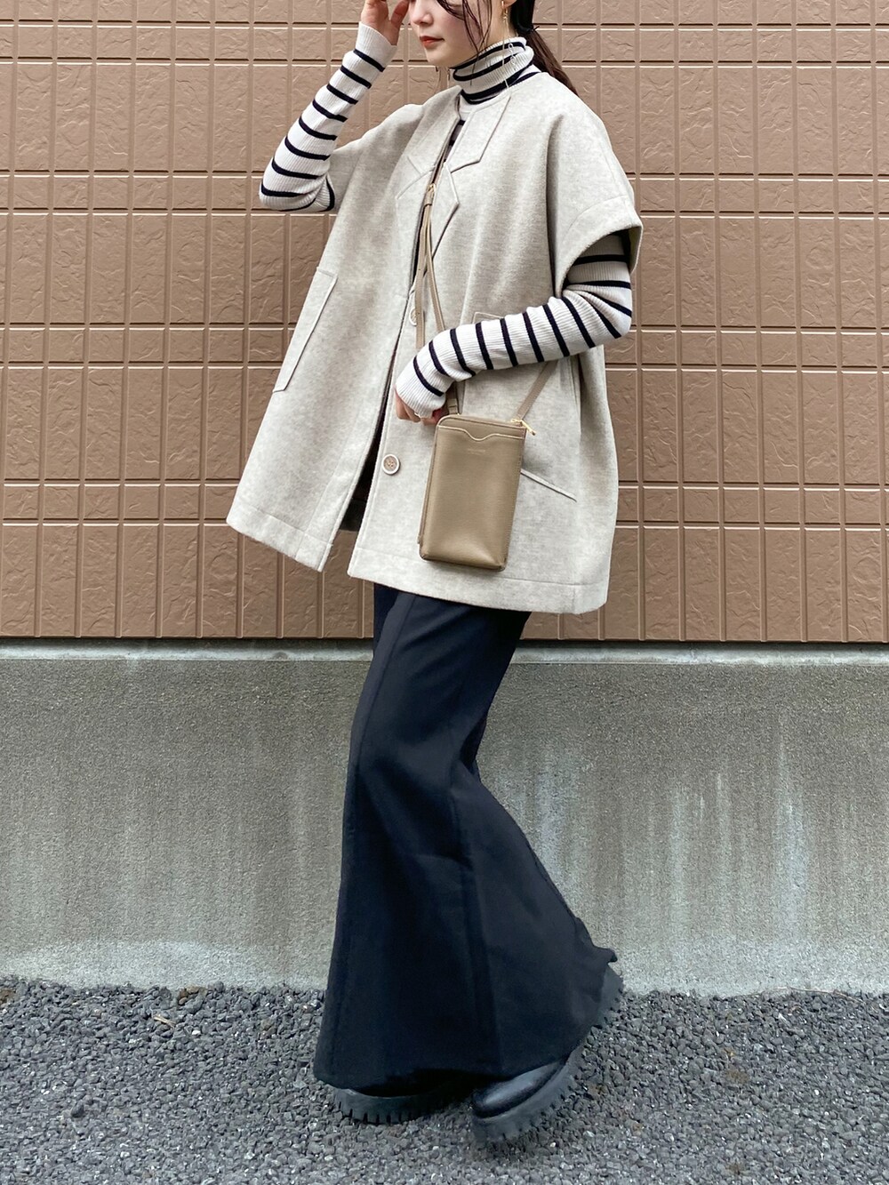 ブラック系のワンピース、ベージュ系のセットアップ、ホワイト系のニット/セーターを着用したレディースの冬コーディネートの2枚目の写真