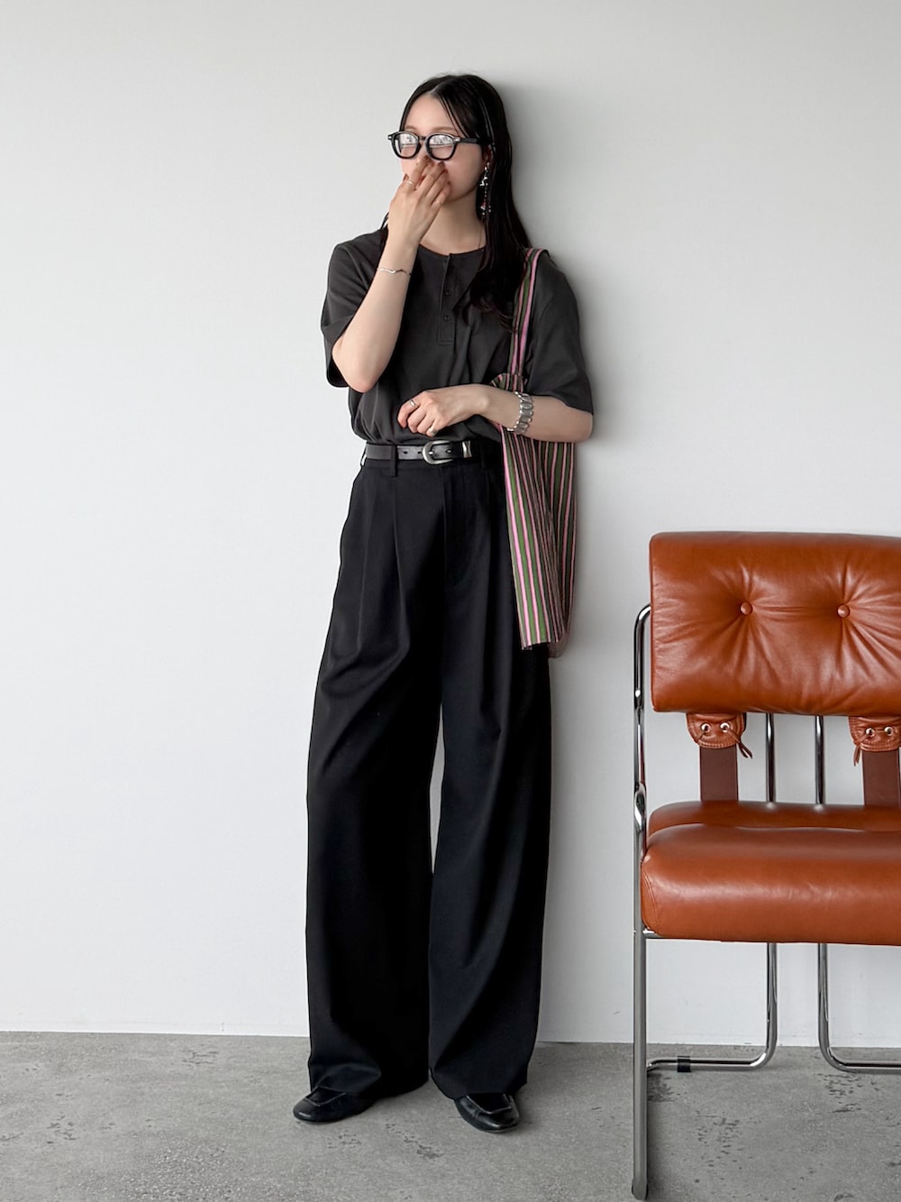 グレー系のTシャツ/カットソー、ブラック系のスラックス、グリーン系のトートバッグを着用したレディースの春コーディネートの2枚目の写真