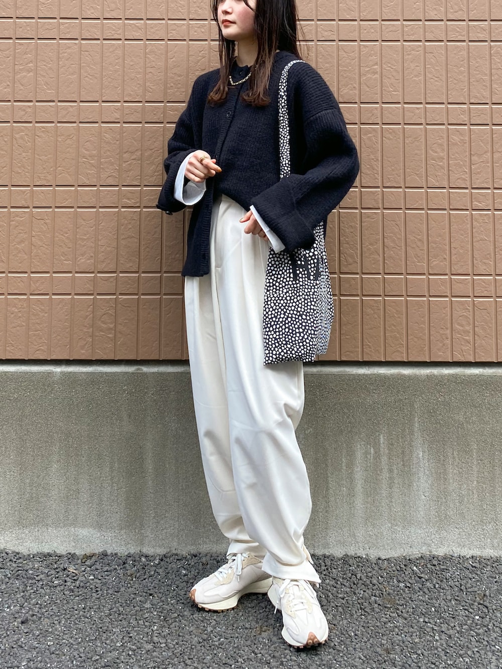 ブラック系のカーディガン/ボレロ、ホワイト系のTシャツ/カットソー、ホワイト系のスニーカーを着用したレディースの冬コーディネートの2枚目の写真