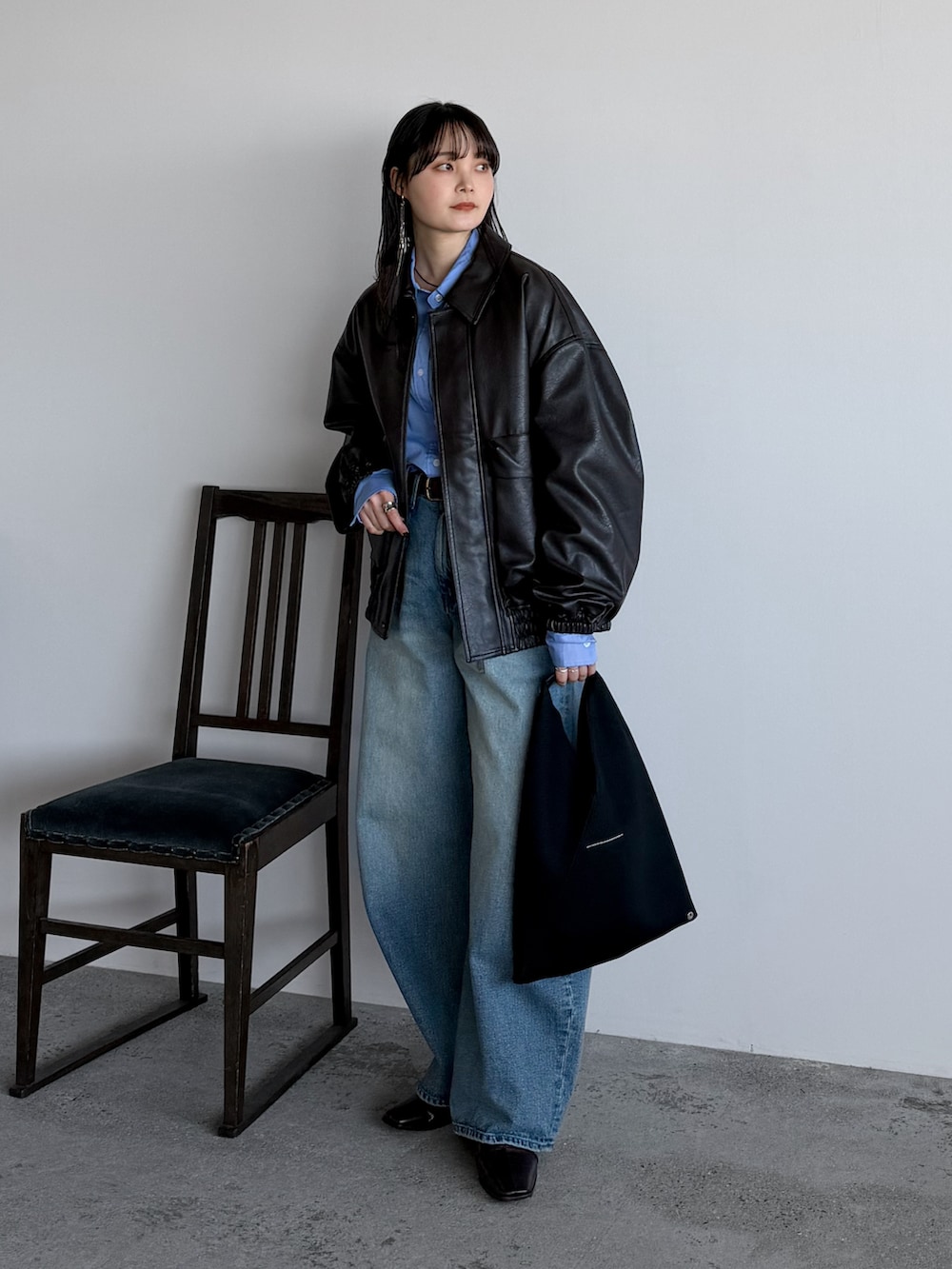 ブラウン系のブルゾン、ブルー系のシャツ/ブラウス、ブルー系のデニムパンツを着用したレディースの冬コーディネートの2枚目の写真