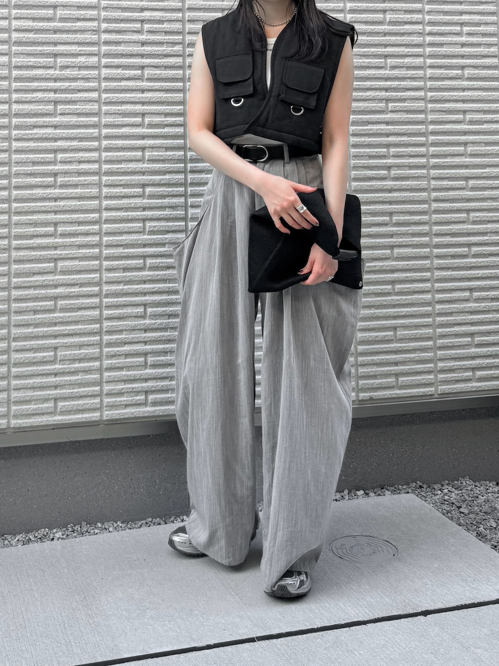 ブラック系のベスト、グレー系のその他パンツ、ブラック系のハンドバッグを着用したレディースの秋コーディネートの2枚目の写真