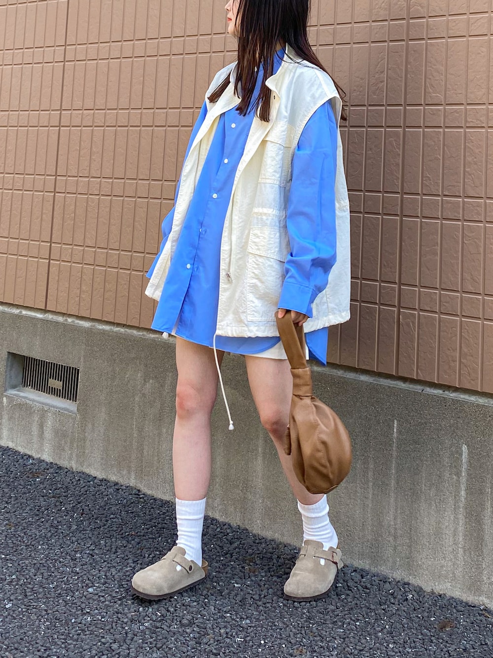 ホワイト系のベスト、ブルー系のシャツ/ブラウス、ホワイト系のパンツを着用したレディースの春コーディネートの2枚目の写真