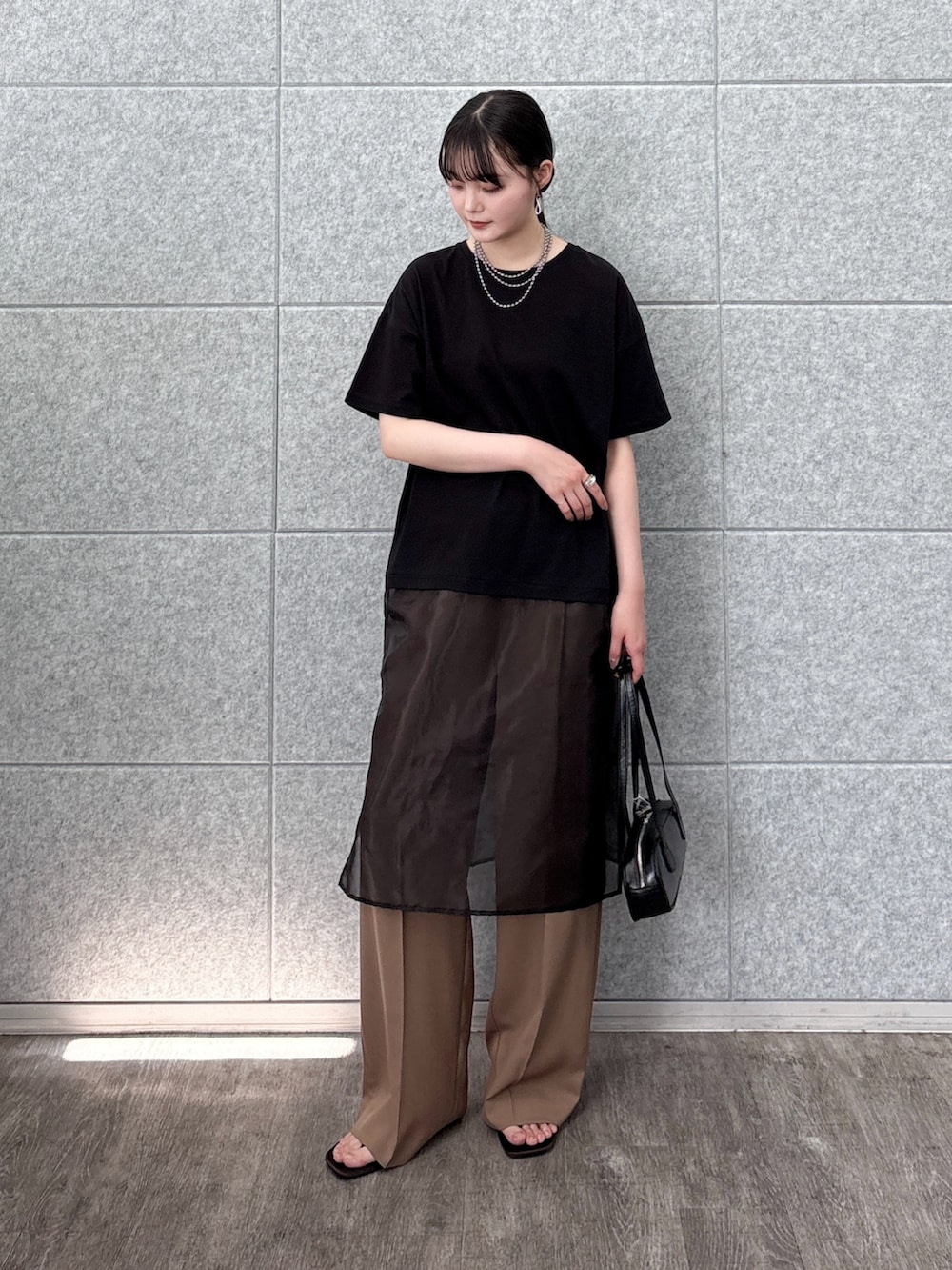 ブラック系のハンドバッグ、ブラック系のTシャツ/カットソー、イエロー系のその他パンツを着用したレディースの夏コーディネートの2枚目の写真