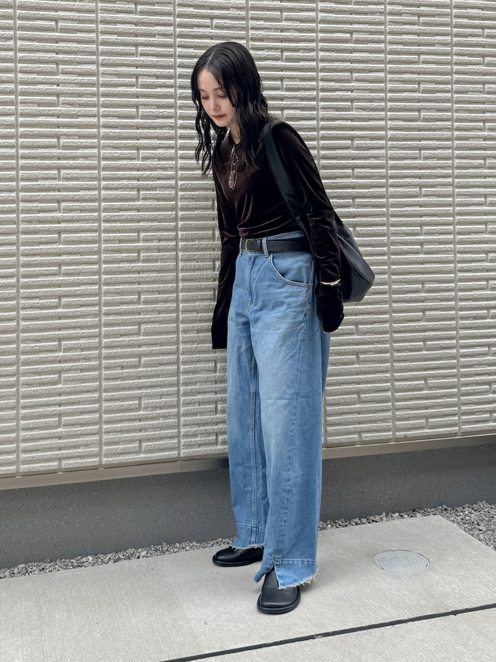 ブラウン系のTシャツ/カットソー、ブルー系のデニムパンツ、ブラック系のショルダーバッグを着用したレディースの秋コーディネートの3枚目の写真