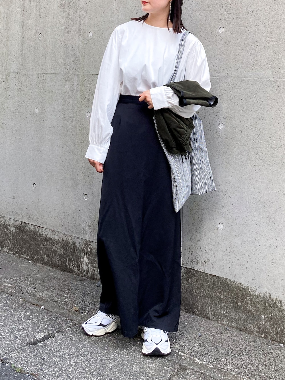 ホワイト系のシャツ/ブラウス、グリーン系のベスト、ホワイト系のスニーカーを着用したレディースの夏コーディネートの2枚目の写真