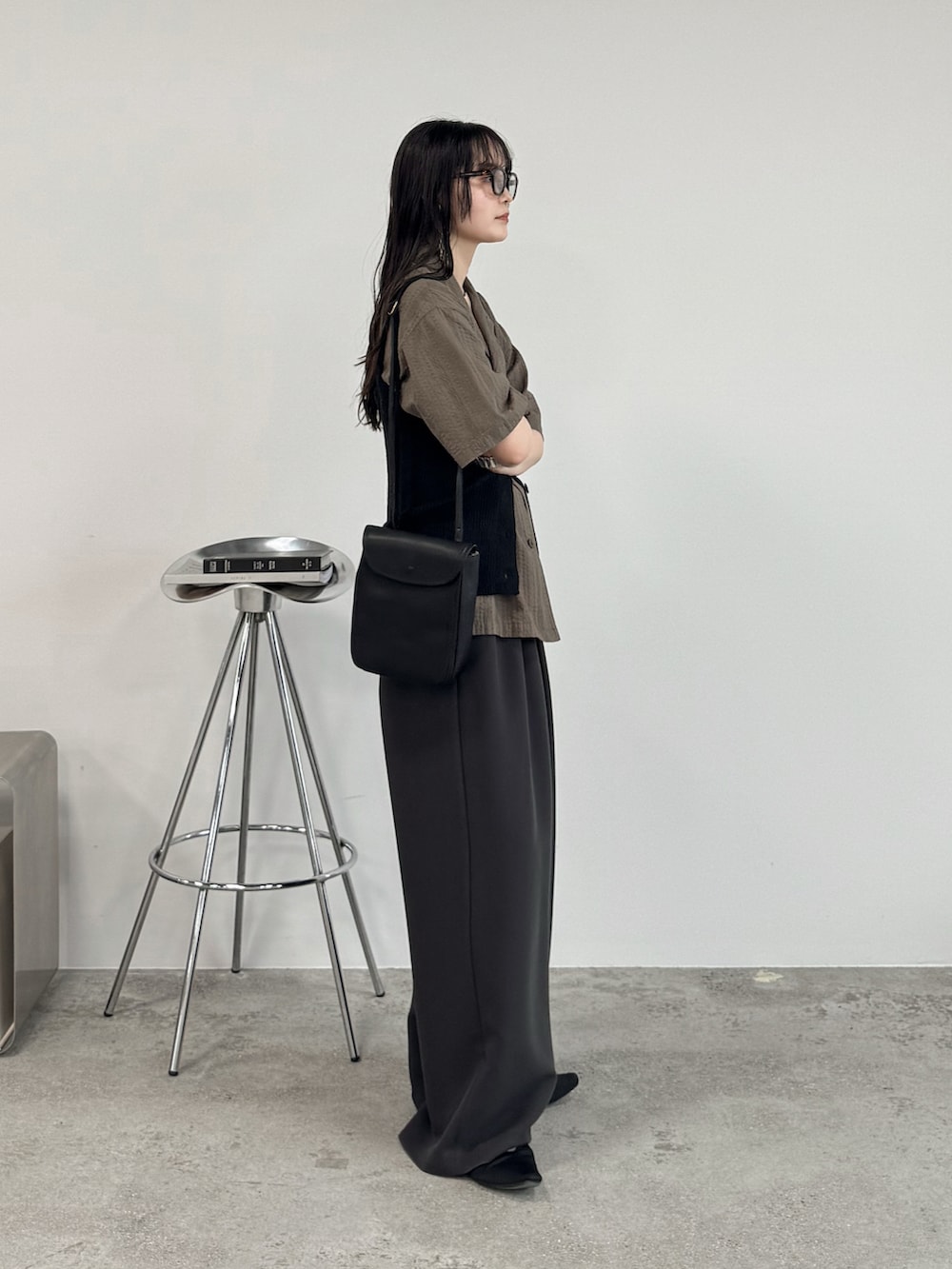 ブラウン系のシャツ/ブラウス、ブラック系のベスト、ブラウン系のスラックスを着用したレディースの夏コーディネートの2枚目の写真