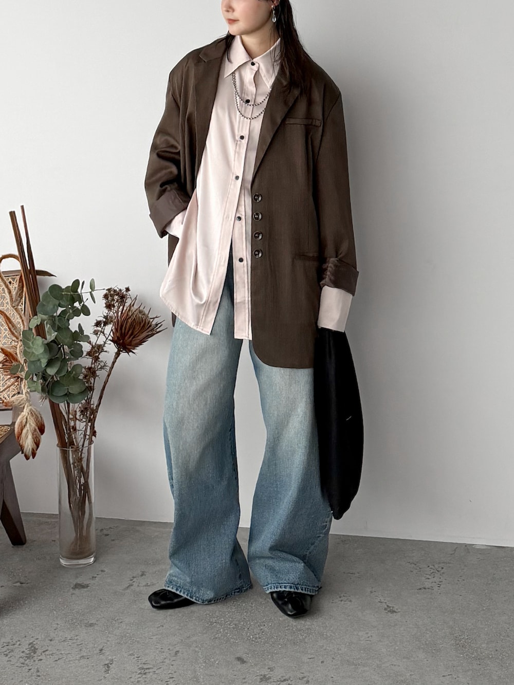 ピンク系のシャツ/ブラウス、ブラウン系のテーラードジャケット、ブルー系のデニムパンツを着用したレディースの春コーディネートの2枚目の写真