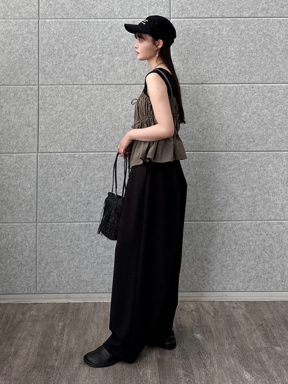 グリーン系のタンクトップ、ブラック系のトートバッグ、ブラック系のタンクトップを着用したレディースの夏コーディネートの2枚目の写真