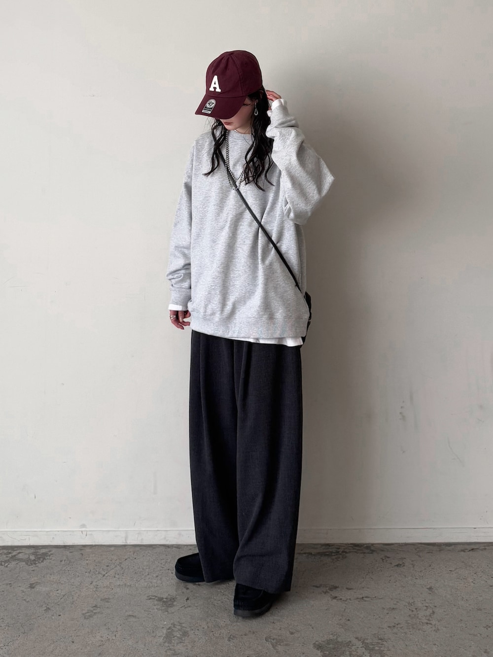 グレー系のスウェット、ホワイト系のTシャツ/カットソー、グレー系のスラックスを着用したレディースの冬コーディネートの3枚目の写真