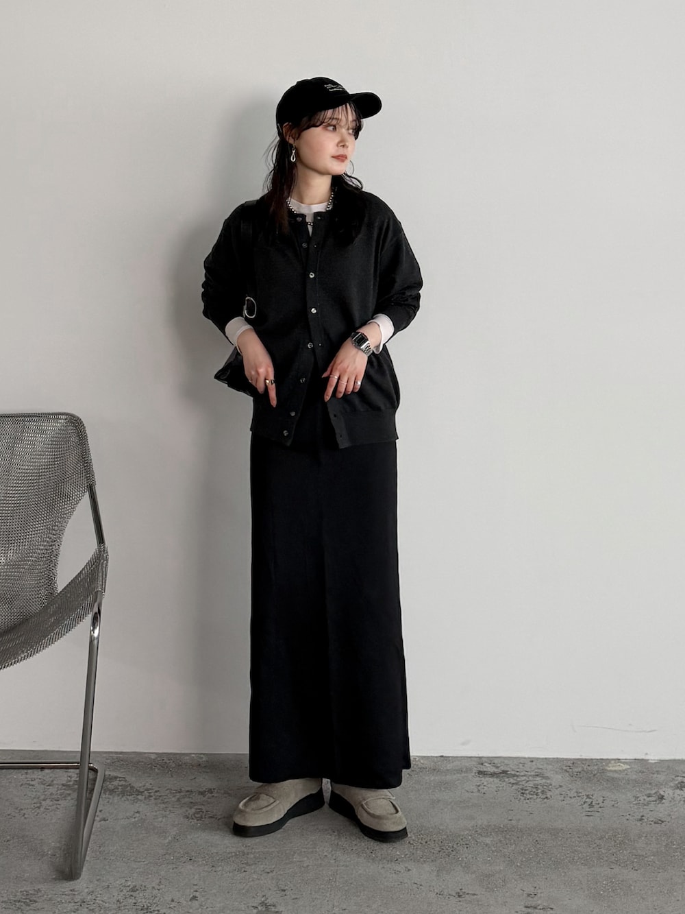 ホワイト系のTシャツ/カットソー、ブラック系のスカート、グレー系のカーディガン/ボレロを着用したレディースの春コーディネートの2枚目の写真