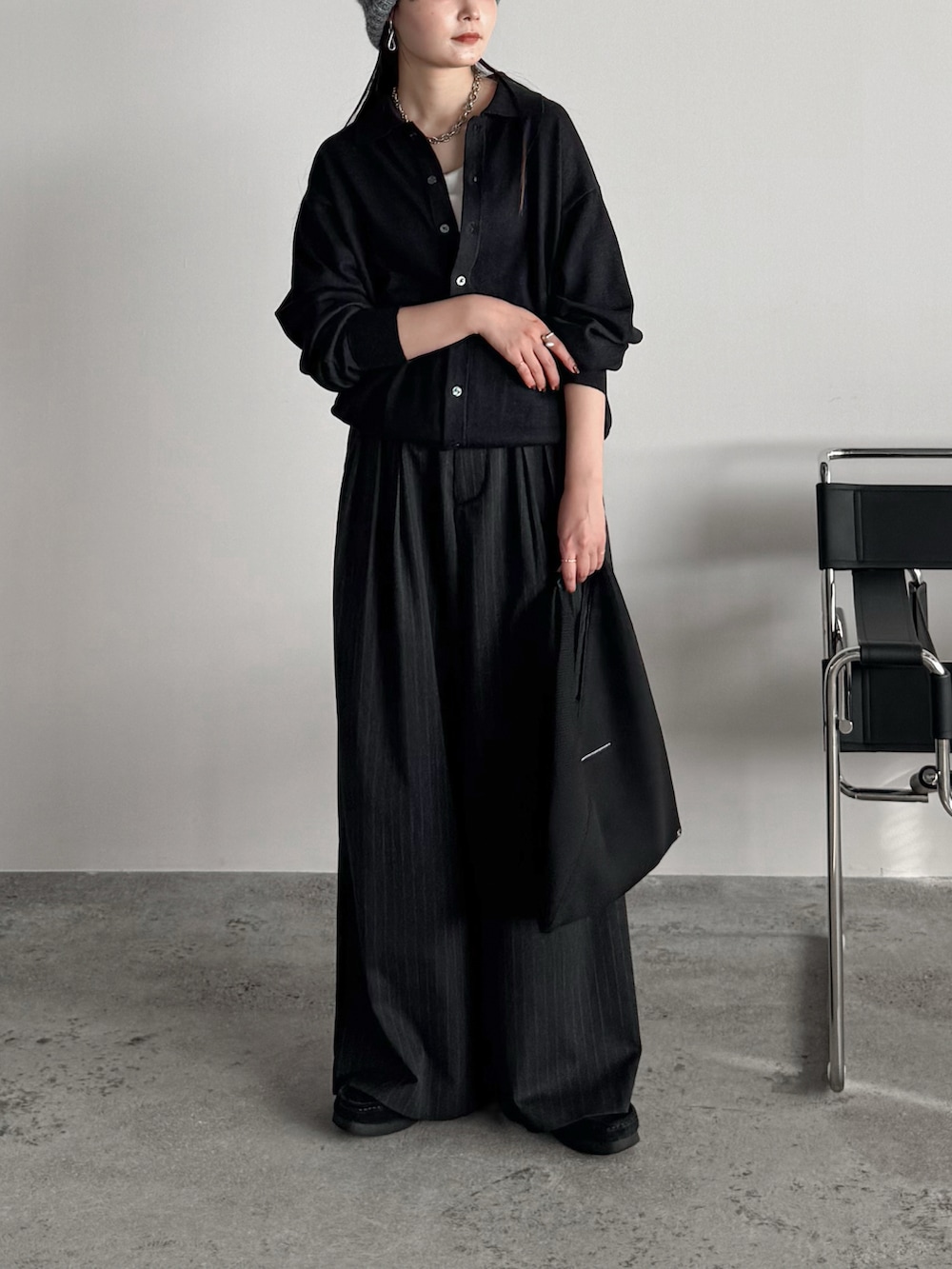 ブラック系のモカシン/デッキシューズ、グレー系のシャツ/ブラウス、グレー系のスラックスを着用したレディースの秋コーディネートの2枚目の写真