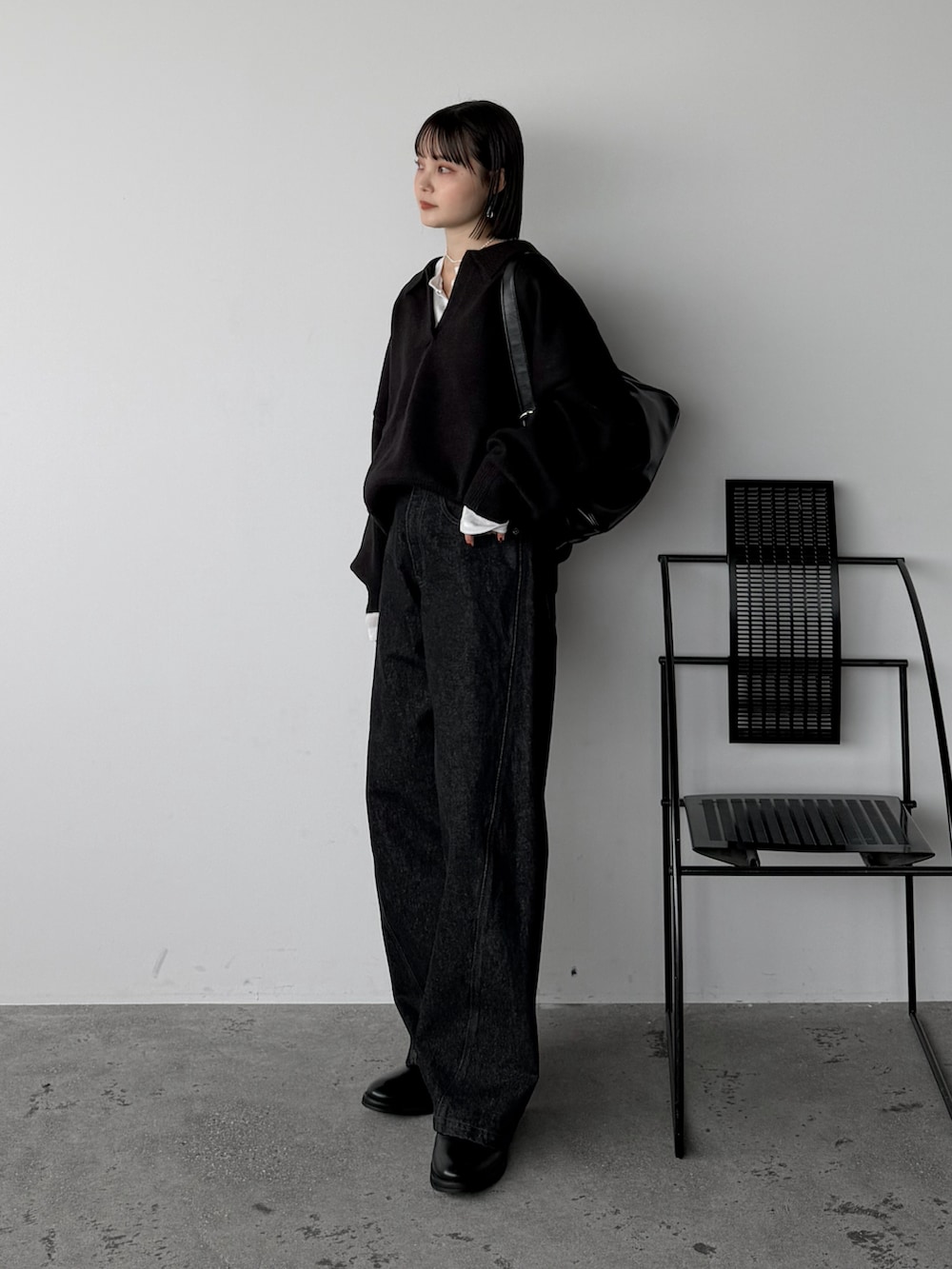 ブラック系のニット/セーター、ホワイト系のカーディガン/ボレロ、ブラック系のデニムパンツを着用したレディースの秋コーディネートの3枚目の写真