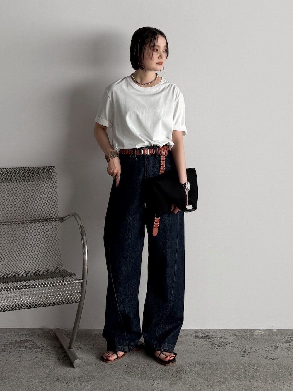 ホワイト系のTシャツ/カットソー、ブルー系のデニムパンツ、ブラック系のハンドバッグを着用したレディースの夏コーディネートの2枚目の写真