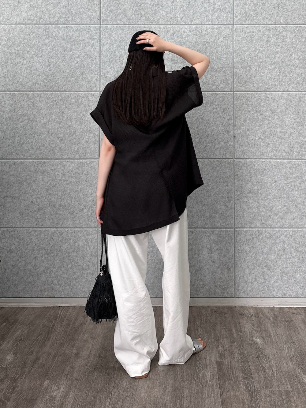 ブラック系のタンクトップ、ブラック系のテーラードジャケット、ホワイト系のデニムパンツを着用したレディースの夏コーディネートの2枚目の写真