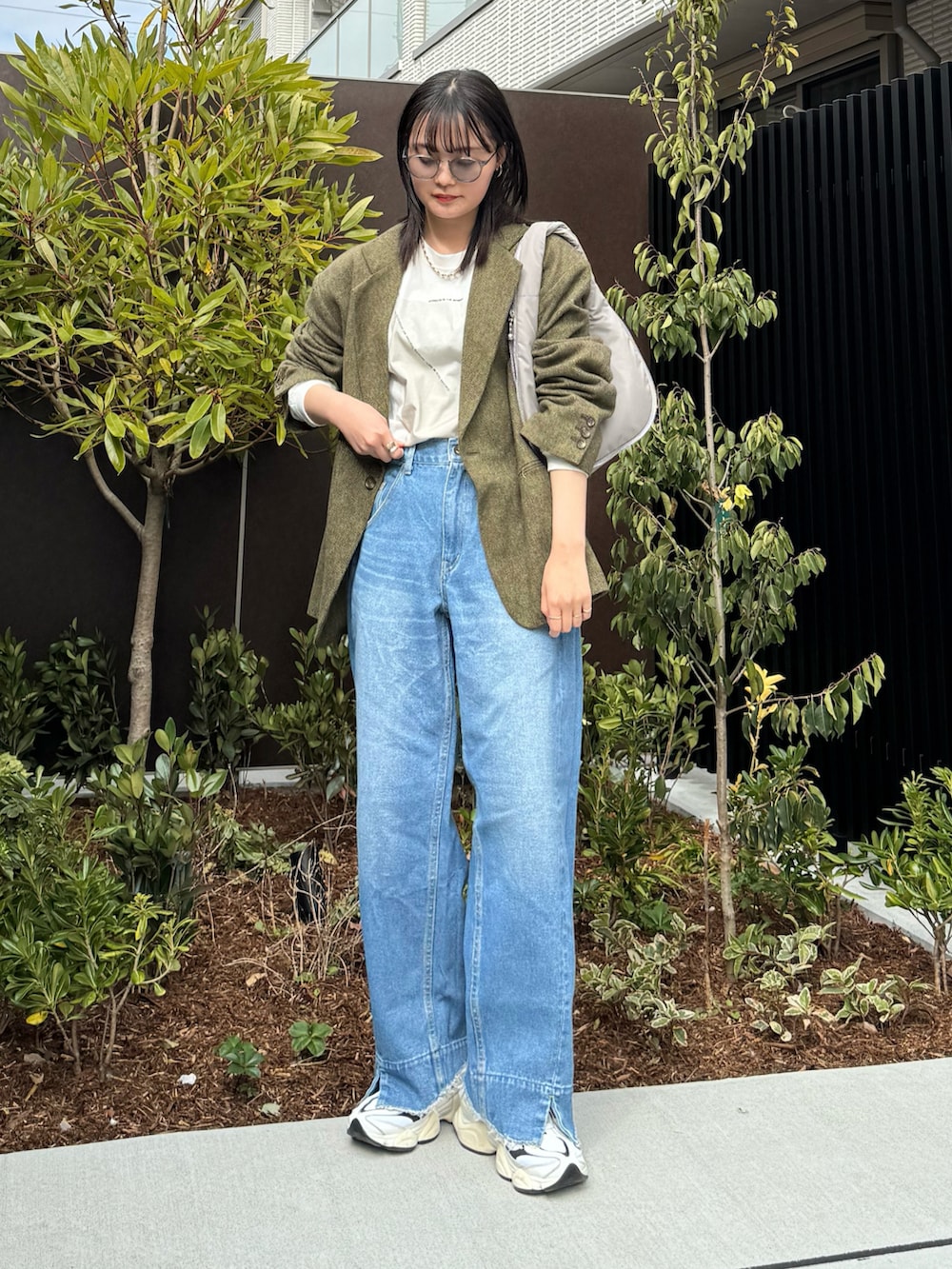 ベージュ系のTシャツ/カットソー、グリーン系のテーラードジャケット、ブルー系のデニムパンツを着用したレディースの冬コーディネートの2枚目の写真