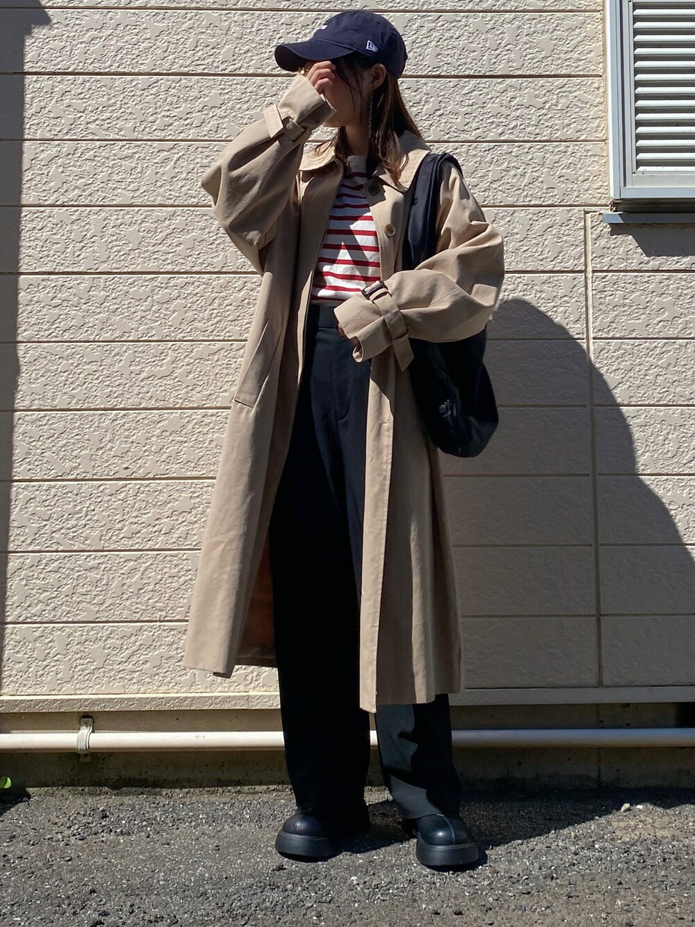 レッド系のTシャツ/カットソー、ブラック系のスラックス、ブラック系のトートバッグを着用したレディースの秋コーディネートの2枚目の写真