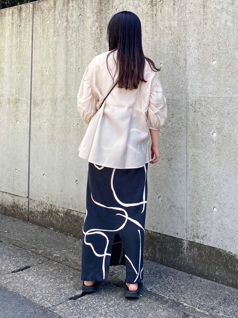 ベージュ系のシャツ/ブラウス、グレー系のスカート、ブラック系のショルダーバッグを着用したレディースの夏コーディネートの2枚目の写真