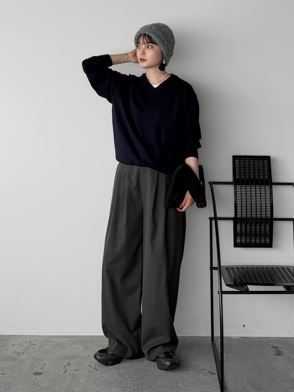 ブルー系のニット/セーター、ホワイト系のTシャツ/カットソー、グレー系のスラックスを着用したレディースの秋コーディネートの2枚目の写真