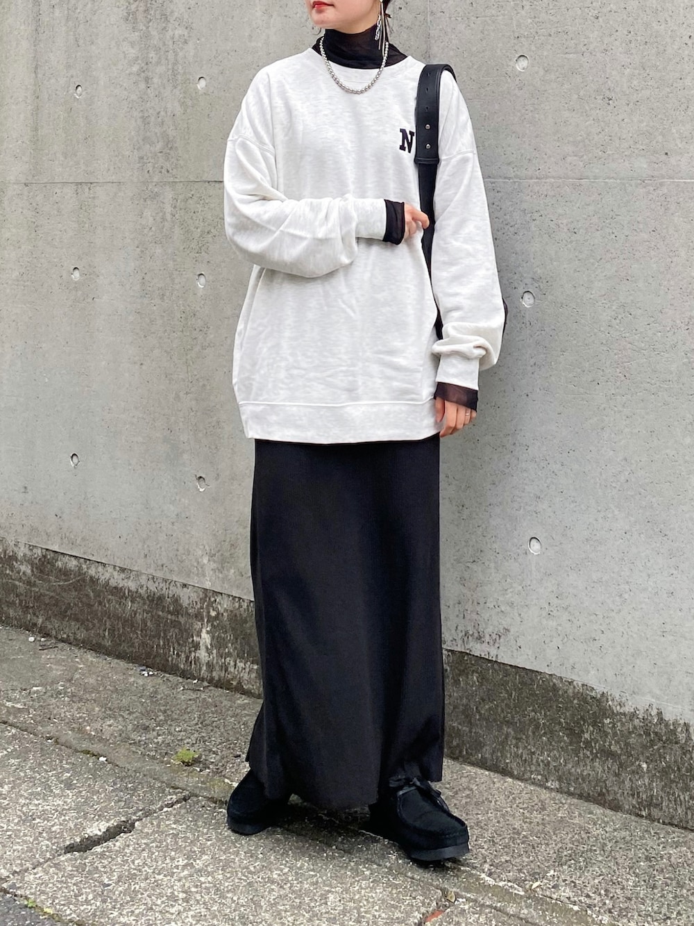 ベージュ系のスウェット、ブラック系のスカート、ブラック系のショルダーバッグを着用したレディースの秋コーディネートの2枚目の写真