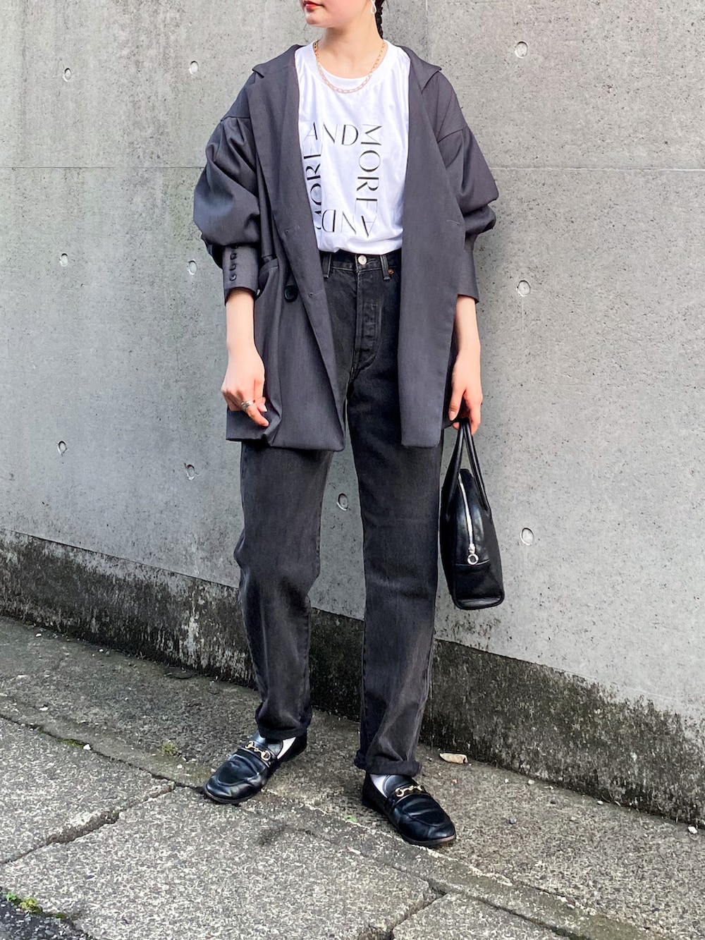 グレー系のテーラードジャケット、ホワイト系のTシャツ/カットソー、ブラック系のデニムパンツを着用したレディースの秋コーディネートの3枚目の写真