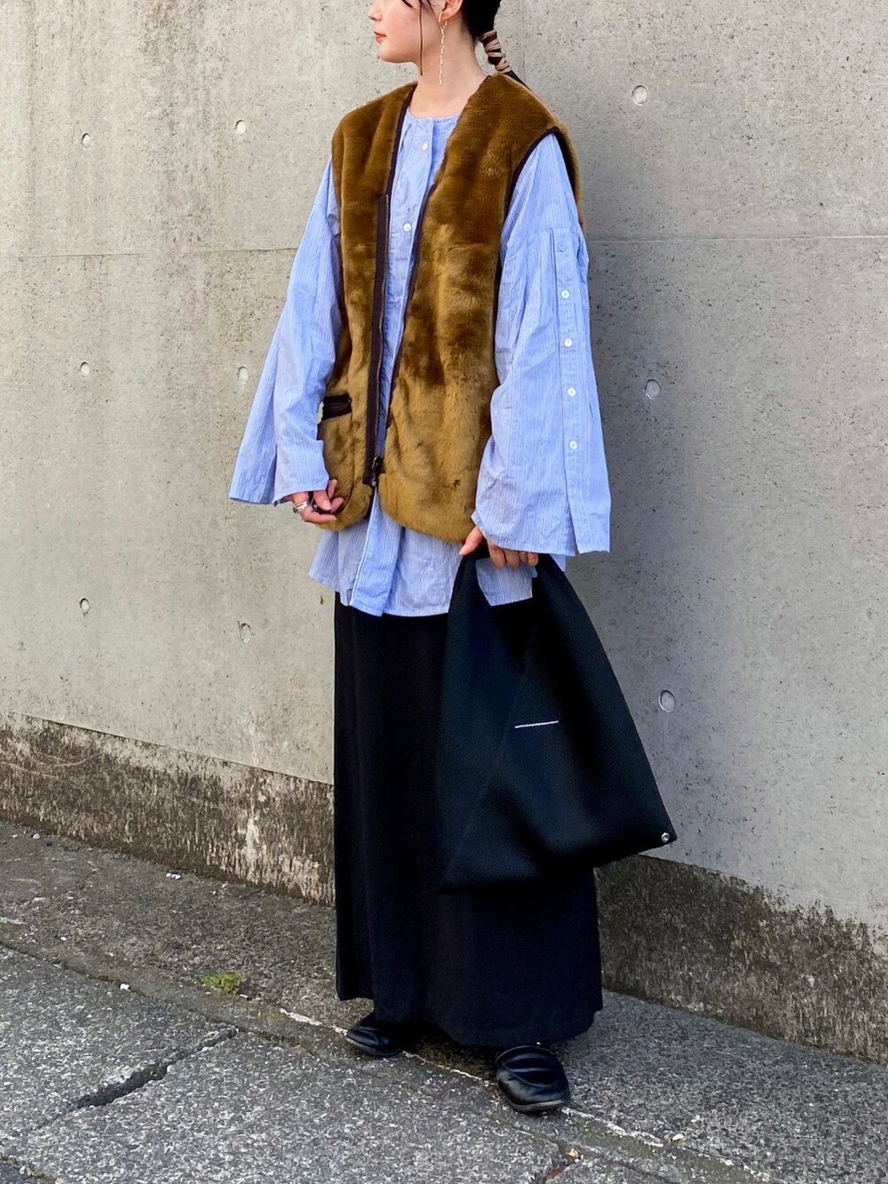 ブラウン系のベスト、ブルー系のシャツ/ブラウス、ブラック系のスカートを着用したレディースの秋コーディネートの2枚目の写真
