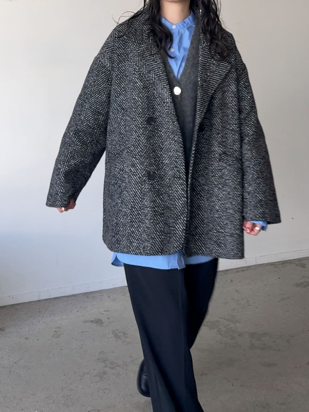 ブラック系のテーラードジャケット、グレー系のカーディガン/ボレロ、ブラック系のその他パンツを着用したレディースの冬コーディネートの3枚目の写真