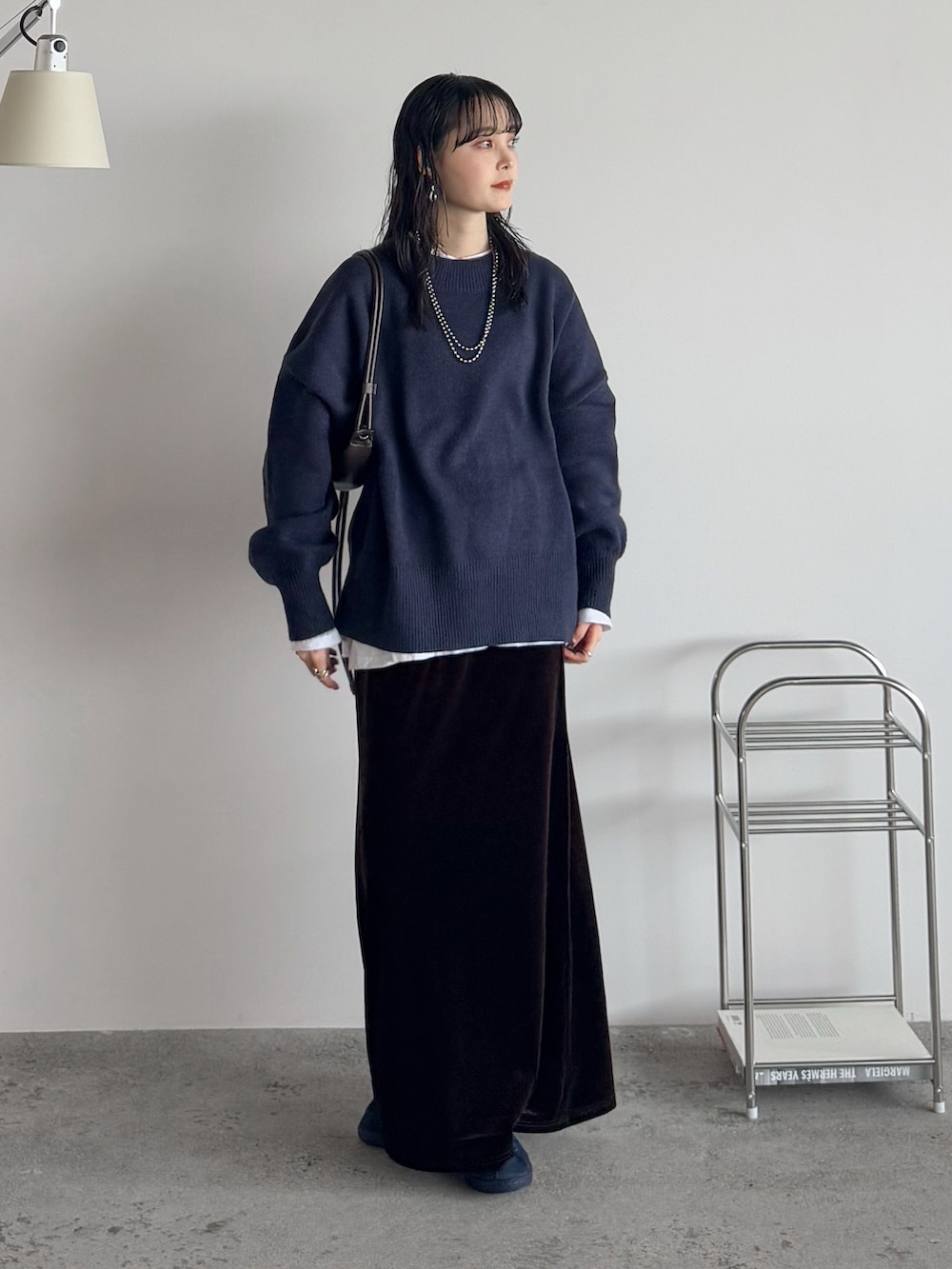 ブルー系のニット/セーター、ホワイト系のTシャツ/カットソー、ブラウン系のスカートを着用したレディースの秋コーディネートの2枚目の写真