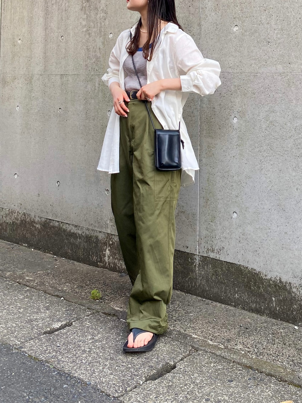 ホワイト系のシャツ/ブラウス、グリーン系のパンツ、ブラック系のショルダーバッグを着用したレディースの春コーディネートの2枚目の写真