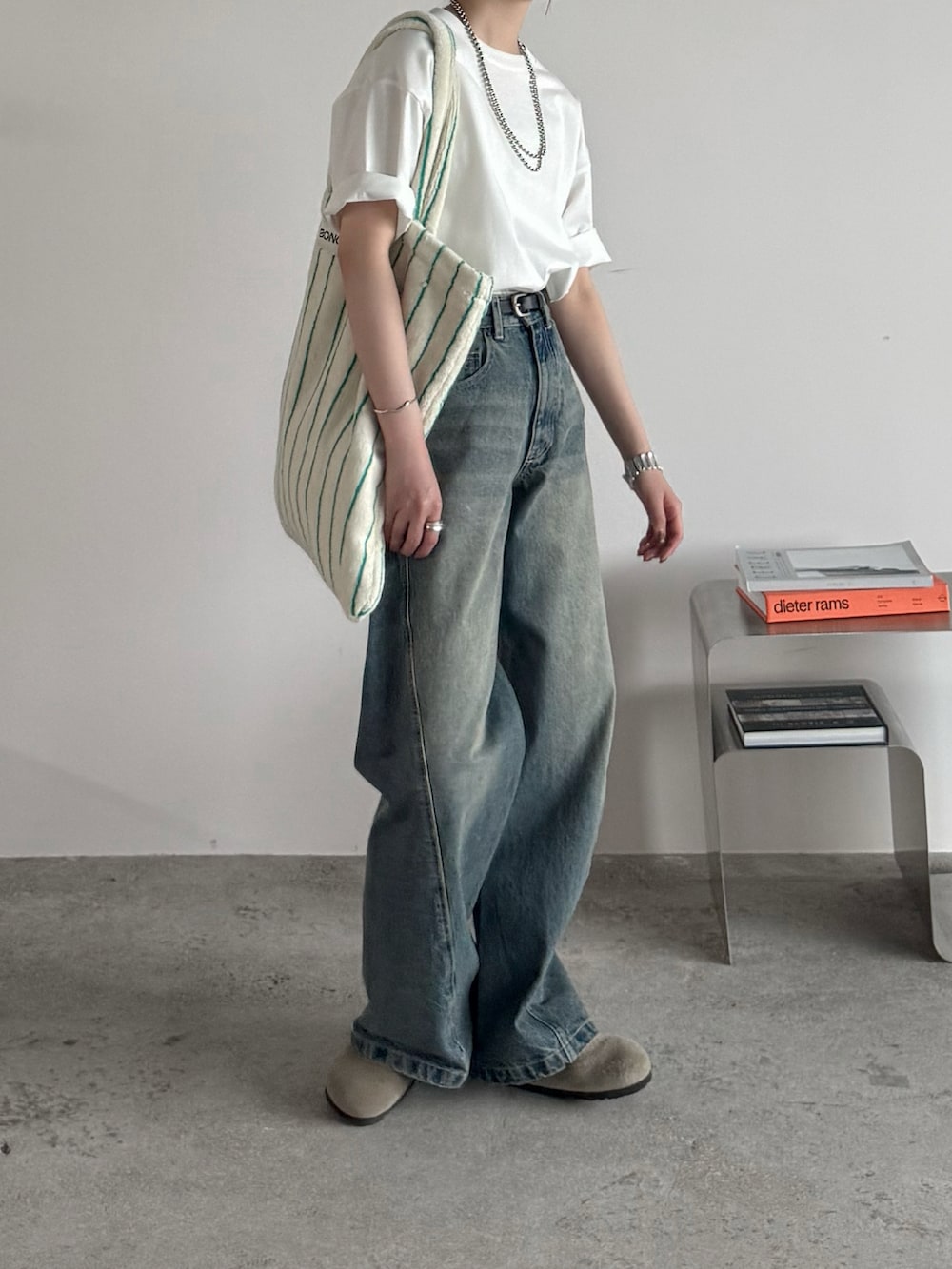 ホワイト系のTシャツ/カットソー、ブルー系のデニムパンツ、ホワイト系のトートバッグを着用したレディースの夏コーディネートの3枚目の写真