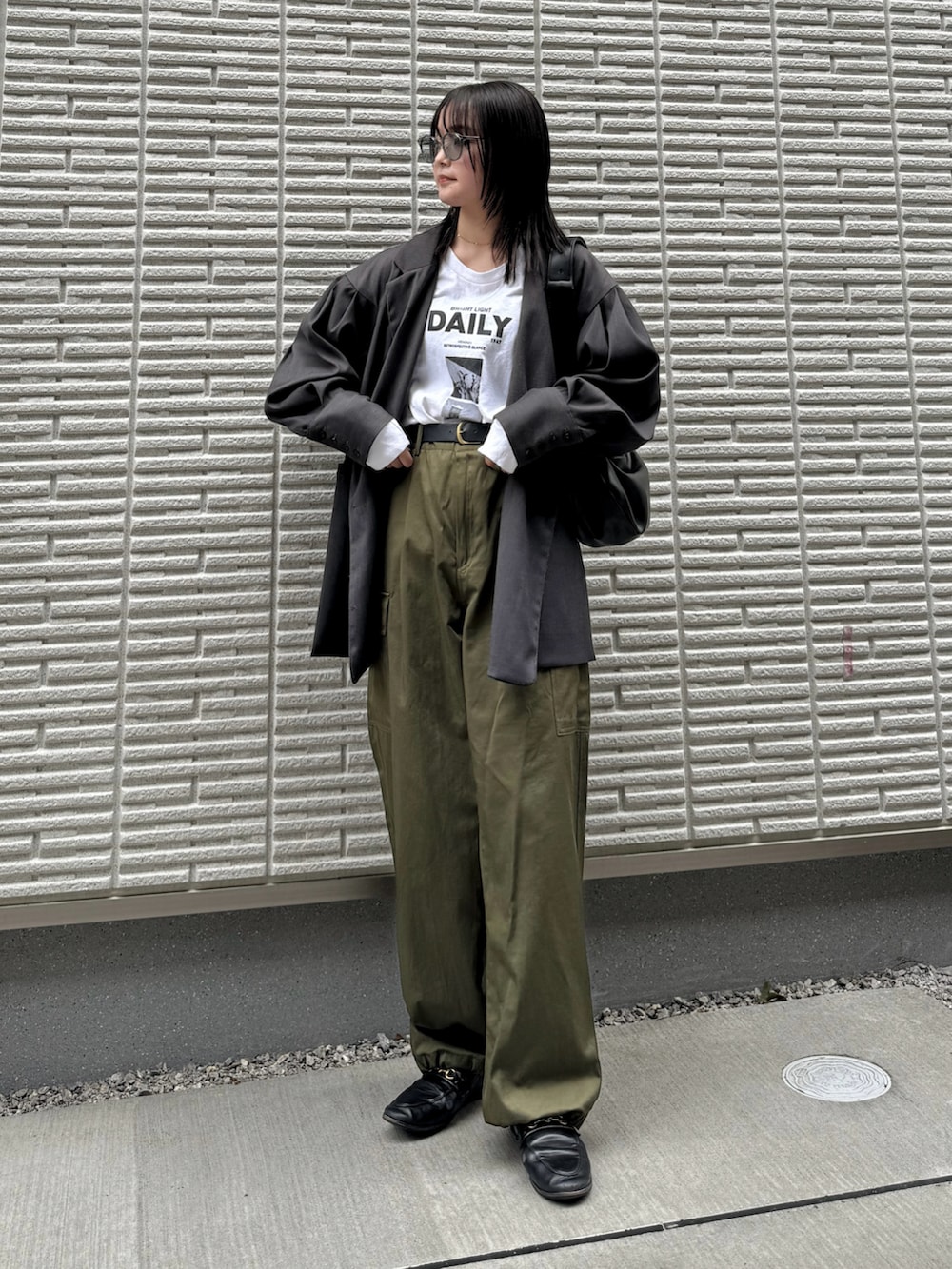 グレー系のテーラードジャケット、ホワイト系のTシャツ/カットソー、グリーン系のパンツを着用したレディースの冬コーディネートの3枚目の写真