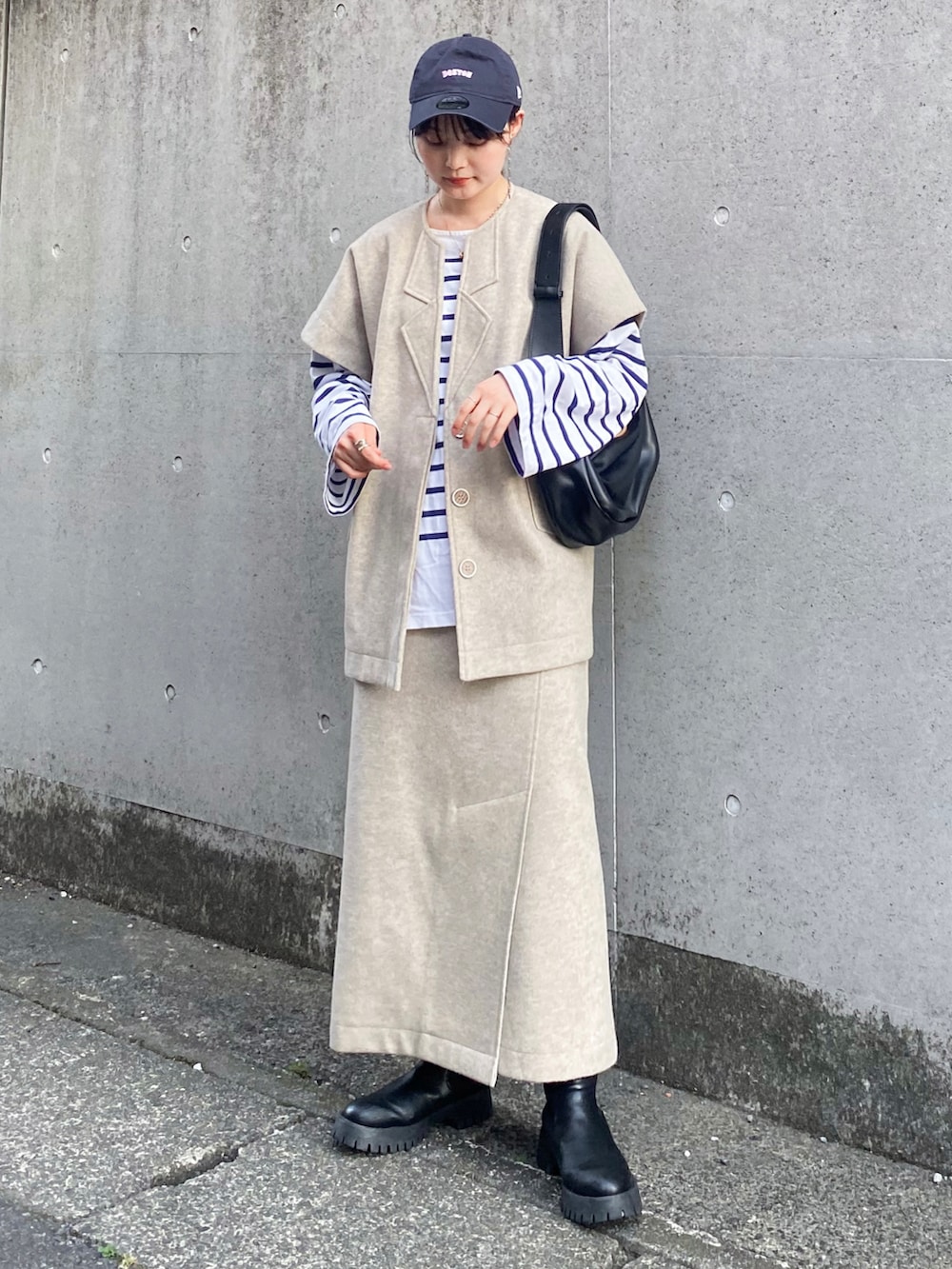 ベージュ系のセットアップ、ブルー系のTシャツ/カットソー、ブラック系のショルダーバッグを着用したレディースの秋コーディネートの2枚目の写真