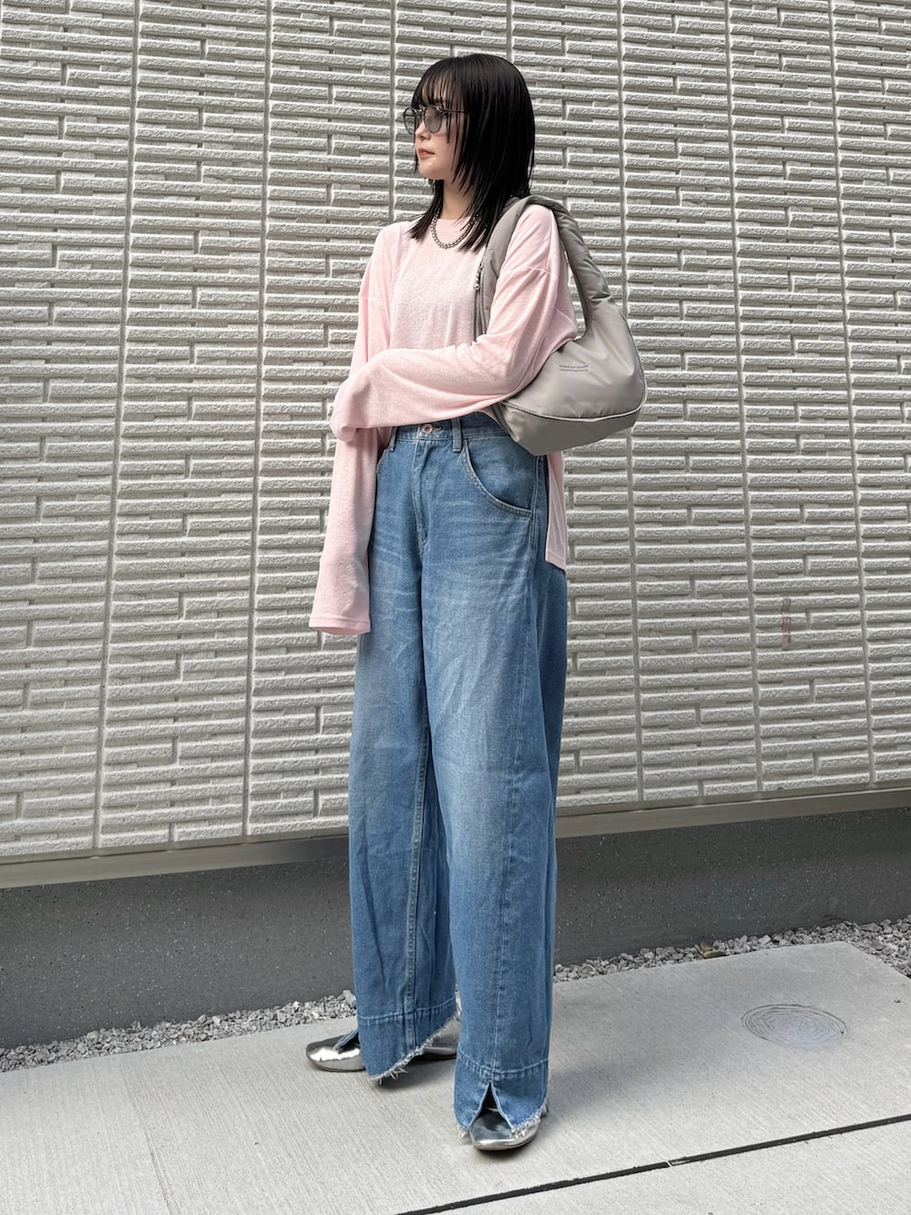 ピンク系のTシャツ/カットソー、ブルー系のデニムパンツ、グレー系のハンドバッグを着用したレディースの冬コーディネートの2枚目の写真