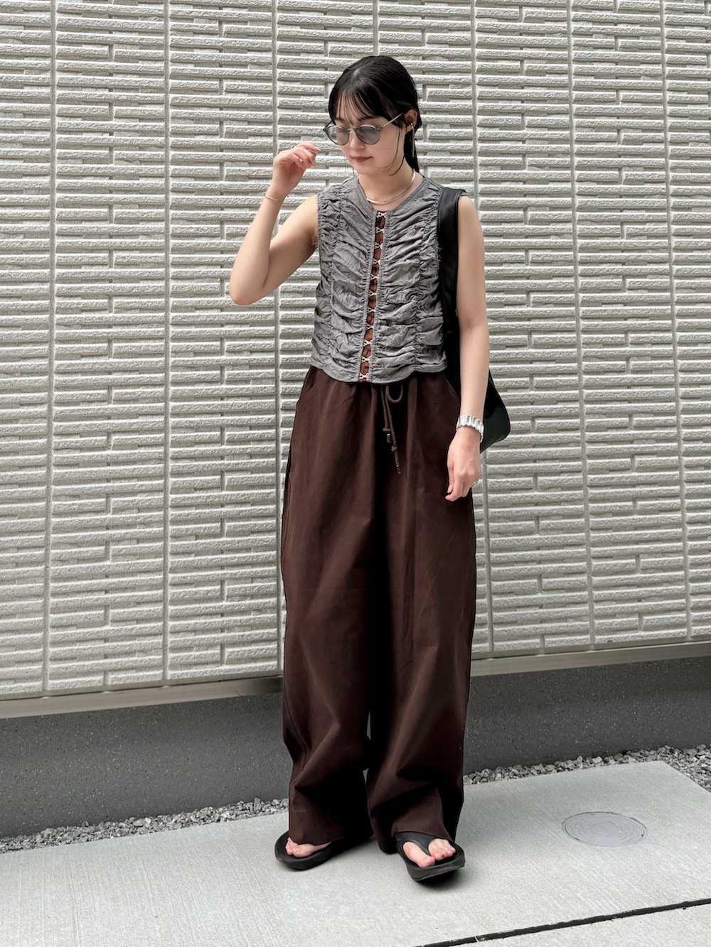 ブルー系のシャツ/ブラウス、レッド系のチノパンツ、ブラック系のショルダーバッグを着用したレディースの夏コーディネートの2枚目の写真