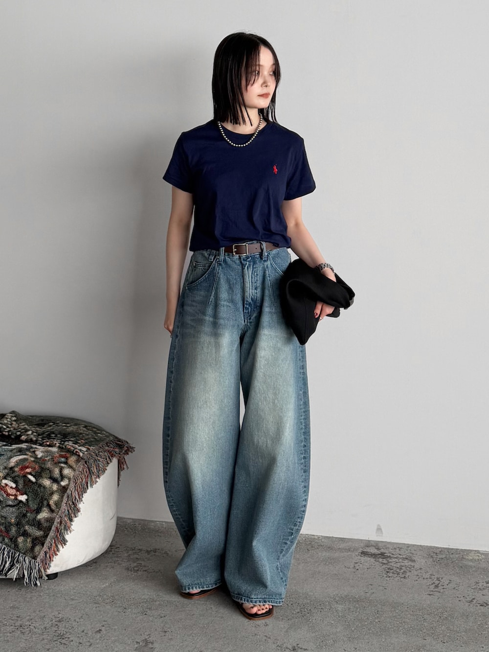 ブルー系のTシャツ/カットソー、ブルー系のデニムパンツ、ブラック系のハンドバッグを着用したレディースの夏コーディネートの2枚目の写真