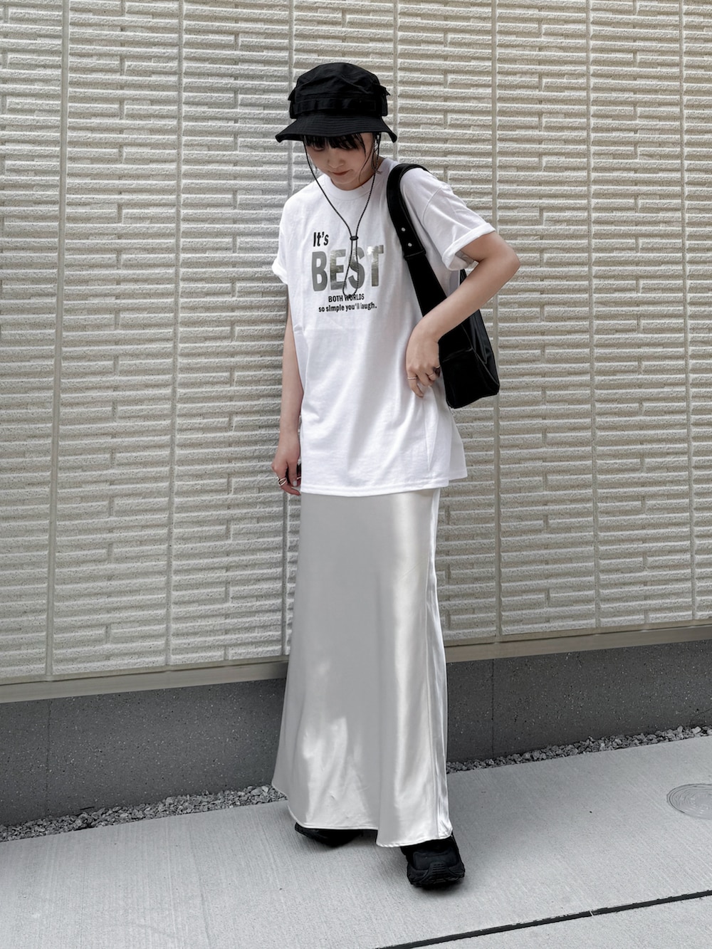 ホワイト系のTシャツ/カットソー、ホワイト系のスカート、ブラック系のショルダーバッグを着用したレディースの春コーディネートの2枚目の写真