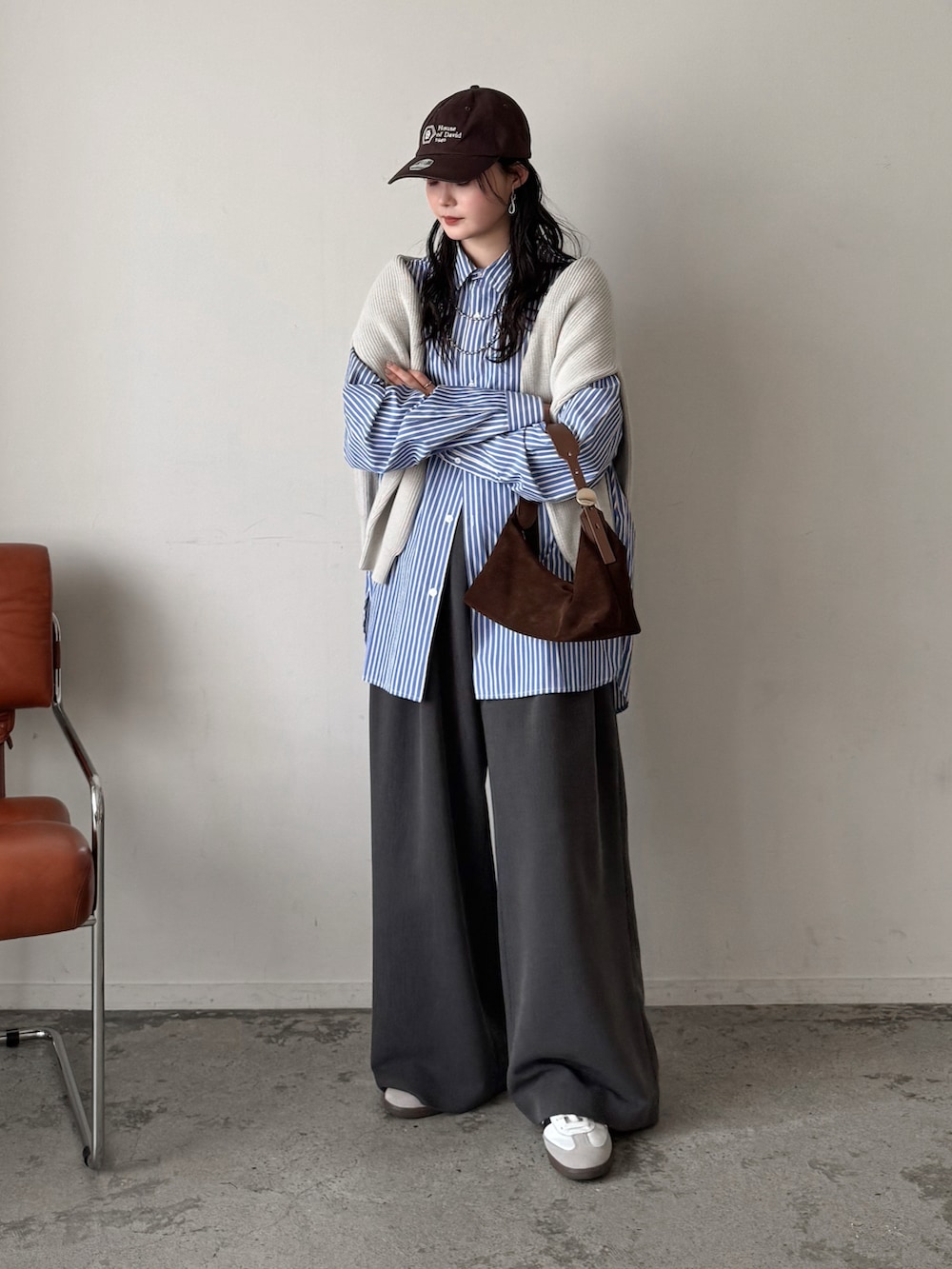 ブルー系のシャツ/ブラウス、ホワイト系のニット/セーター、グレー系のスラックスを着用したレディースの春コーディネートの3枚目の写真
