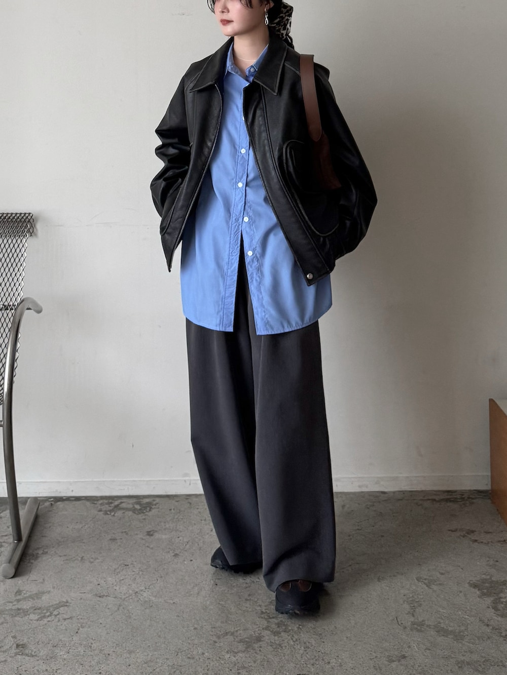 グレー系のブルゾン、ブルー系のシャツ/ブラウス、グレー系のスラックスを着用したレディースの春コーディネートの3枚目の写真