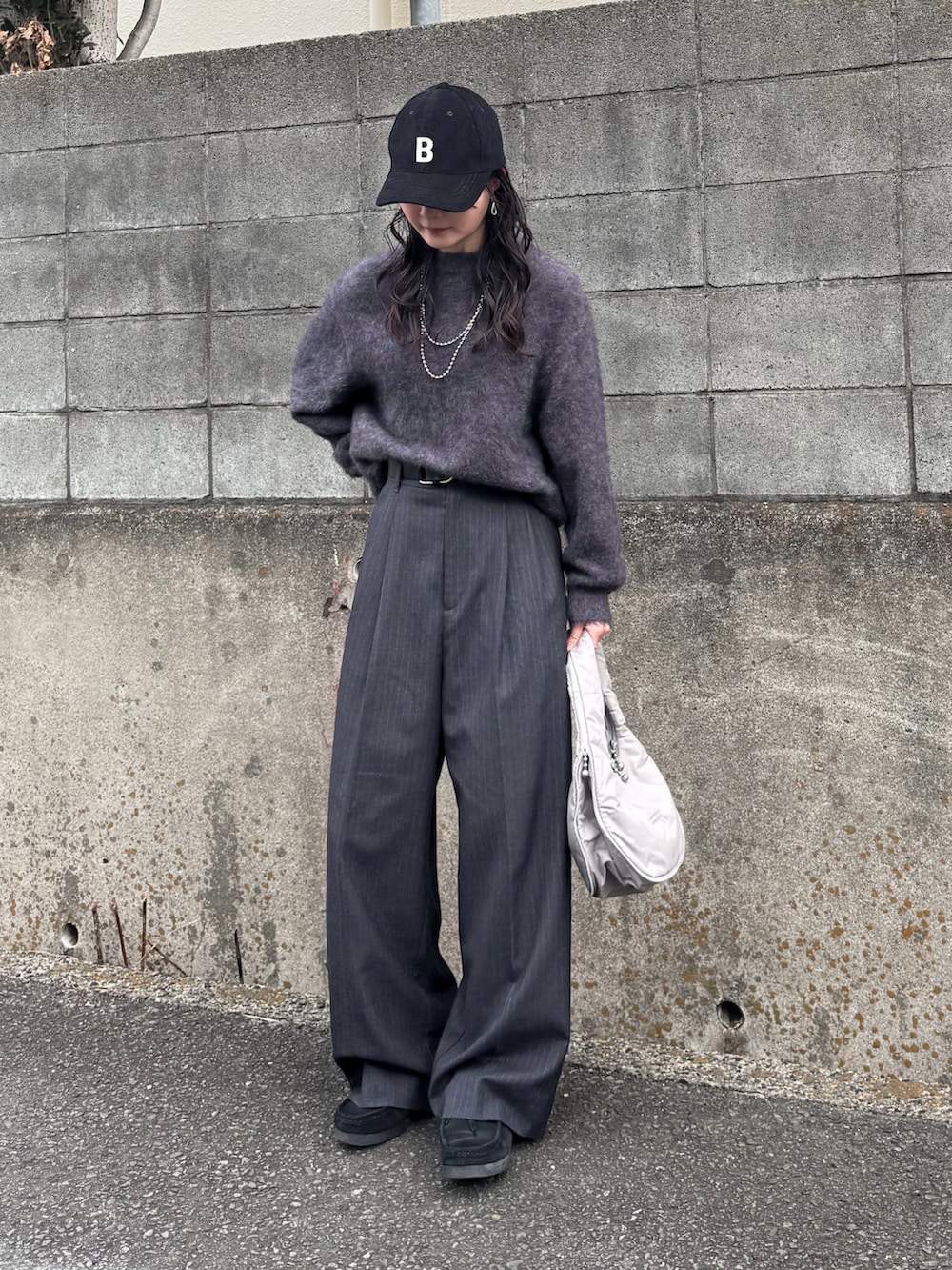 グレー系のニット/セーター、グレー系のその他パンツ、グレー系のハンドバッグを着用したレディースの冬コーディネートの2枚目の写真