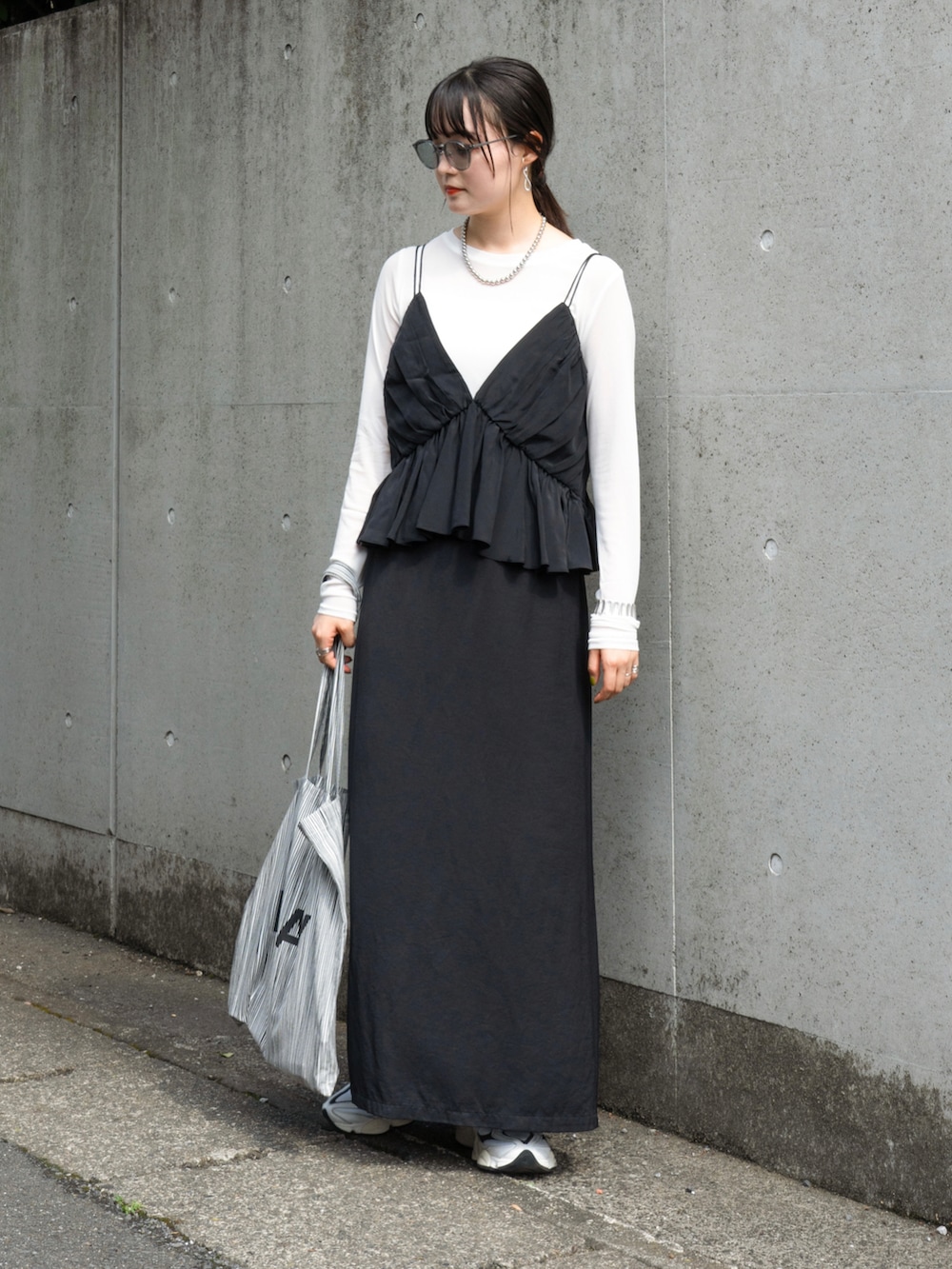 ブラック系のトップス、ホワイト系のTシャツ/カットソー、ホワイト系のスニーカーを着用したレディースの秋コーディネートの3枚目の写真