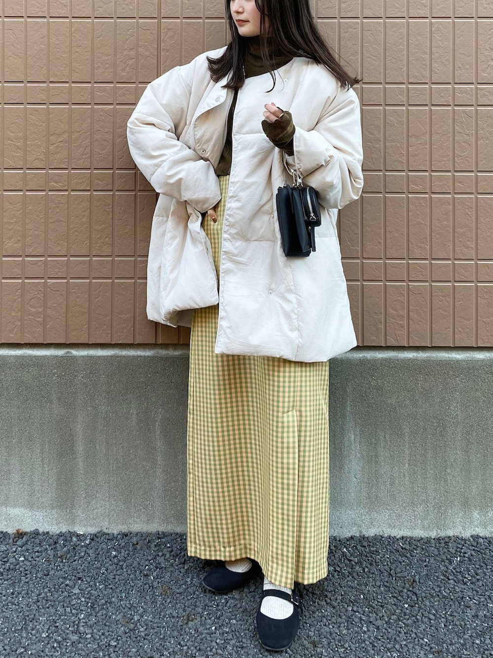 ホワイト系のダウンジャケット/コート、ブラウン系のTシャツ/カットソー、その他のスカートを着用したレディースの冬コーディネートの2枚目の写真