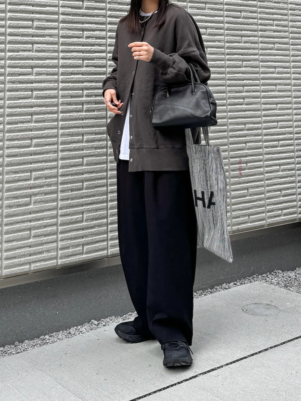 グレー系のスウェット、ホワイト系のTシャツ/カットソー、ブラック系のその他パンツを着用したレディースの冬コーディネートの2枚目の写真