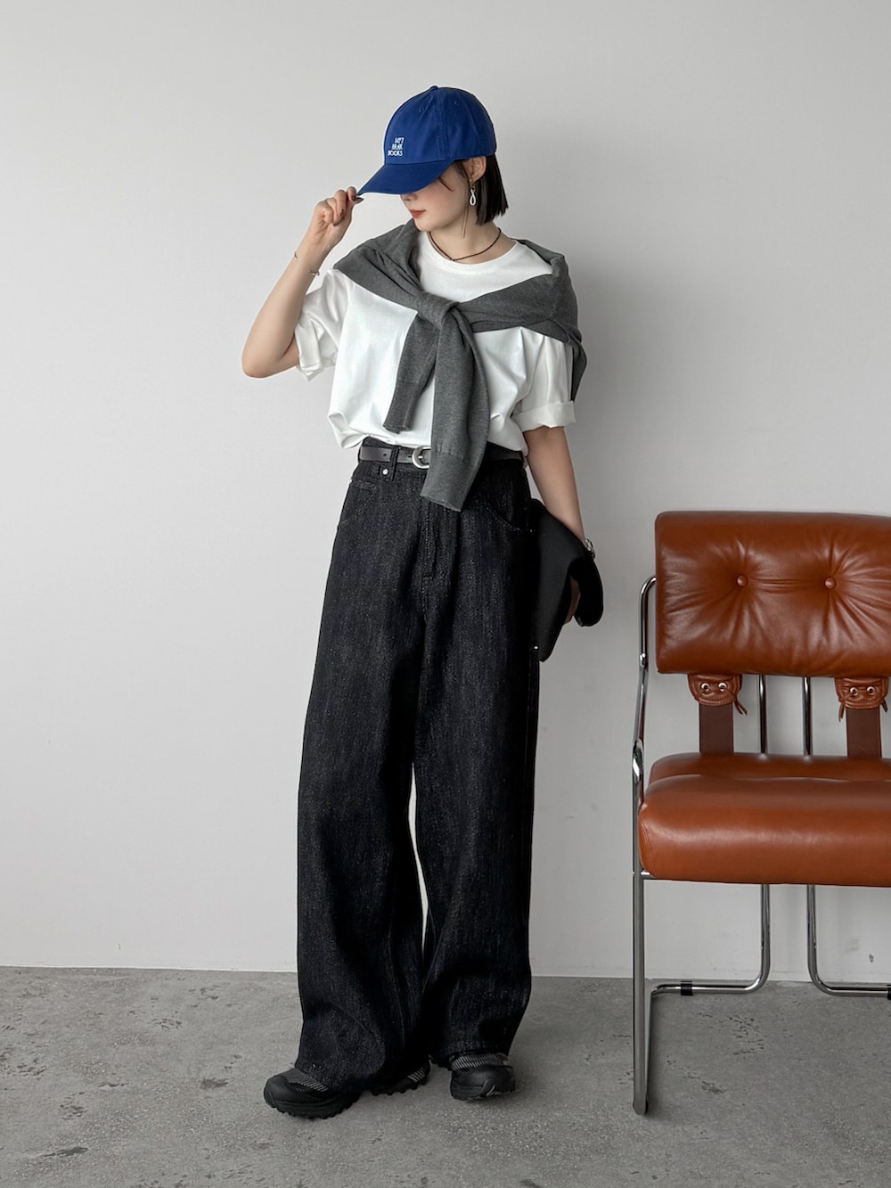 ホワイト系のTシャツ/カットソー、ブラック系のデニムパンツ、ブラック系のスニーカーを着用したレディースの秋コーディネートの2枚目の写真