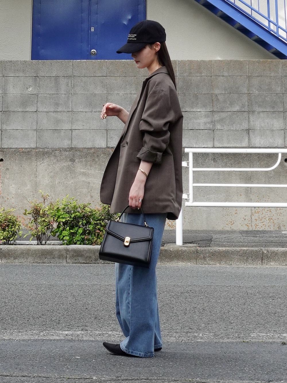 ベージュ系のテーラードジャケット、ブルー系のデニムパンツ、ブラック系のパンプスを着用したレディースの春コーディネートの2枚目の写真