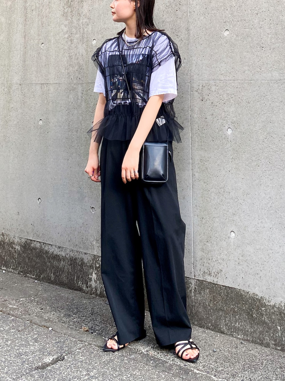 ブラック系のTシャツ/カットソー、ブラック系のスラックス、ブラック系のショルダーバッグを着用したレディースの夏コーディネートの2枚目の写真