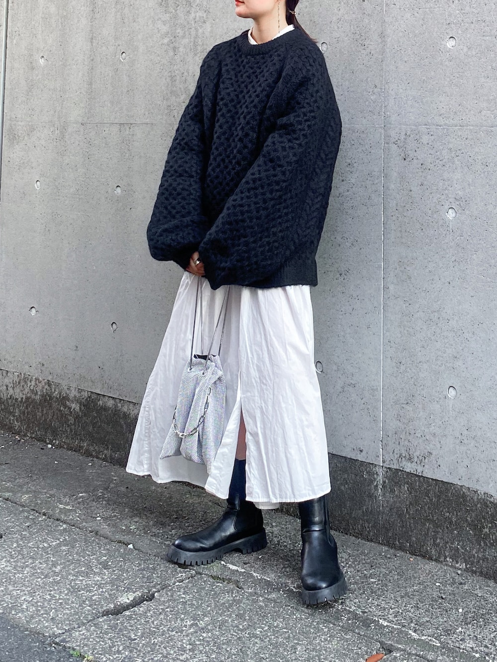 ブラック系のニット/セーター、ホワイト系のシャツワンピース、シルバー系のショルダーバッグを着用したレディースの秋コーディネートの3枚目の写真