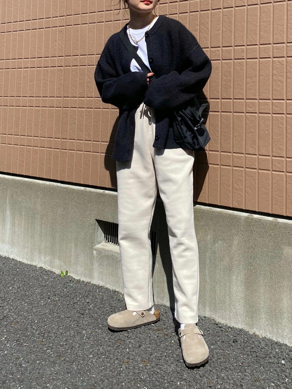 ブラック系のカーディガン/ボレロ、ベージュ系のその他パンツ、ブラック系のショルダーバッグを着用したレディースの春コーディネートの2枚目の写真