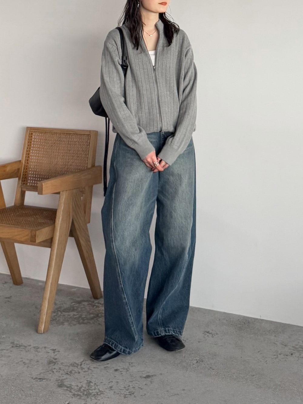 グレー系のニット/セーター、ホワイト系のニット/セーター、ブルー系のデニムパンツを着用したレディースの冬コーディネートの2枚目の写真