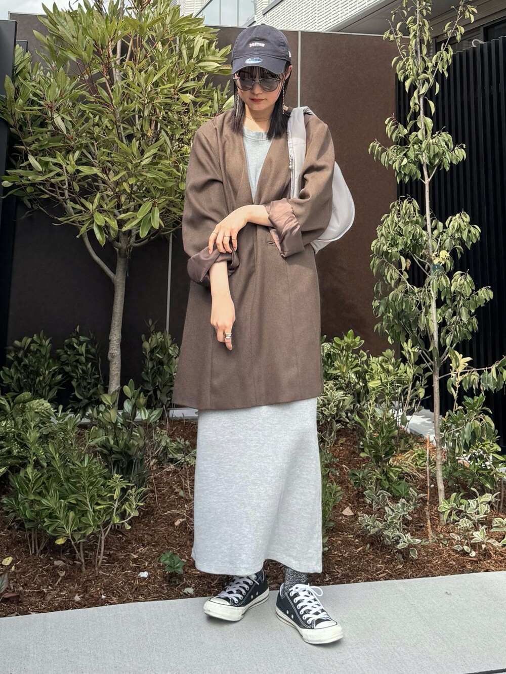 ブラウン系のワンピース、グレー系のワンピース、グレー系のハンドバッグを着用したレディースの冬コーディネートの2枚目の写真