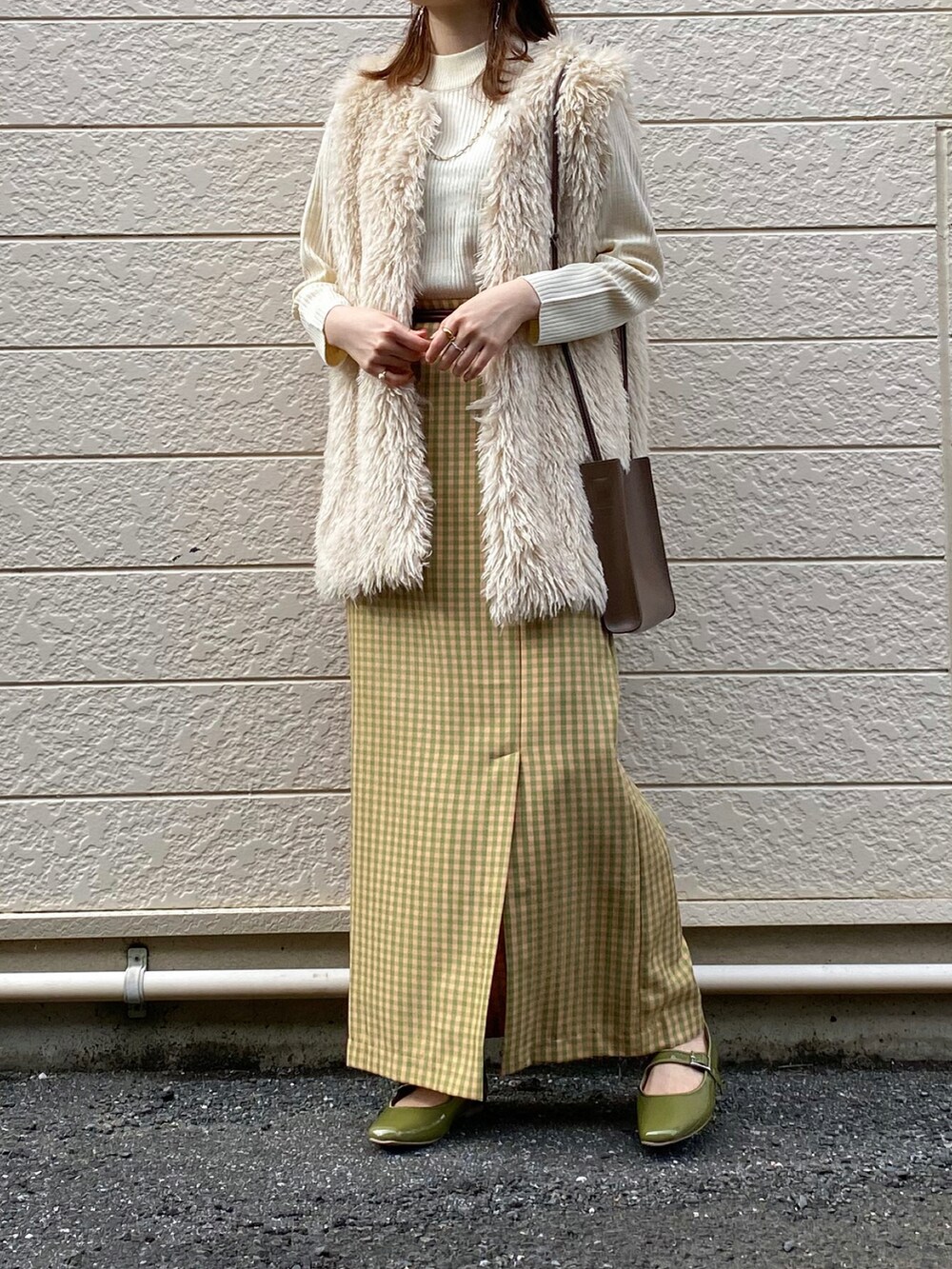 ホワイト系のニット/セーター、ホワイト系のベスト、その他のスカートを着用したレディースの秋コーディネートの2枚目の写真