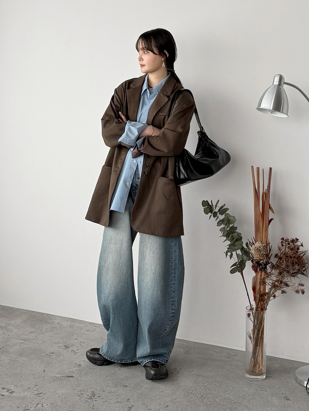 ブルー系のシャツ/ブラウス、ブラウン系のテーラードジャケット、ブルー系のデニムパンツを着用したレディースの春コーディネートの2枚目の写真